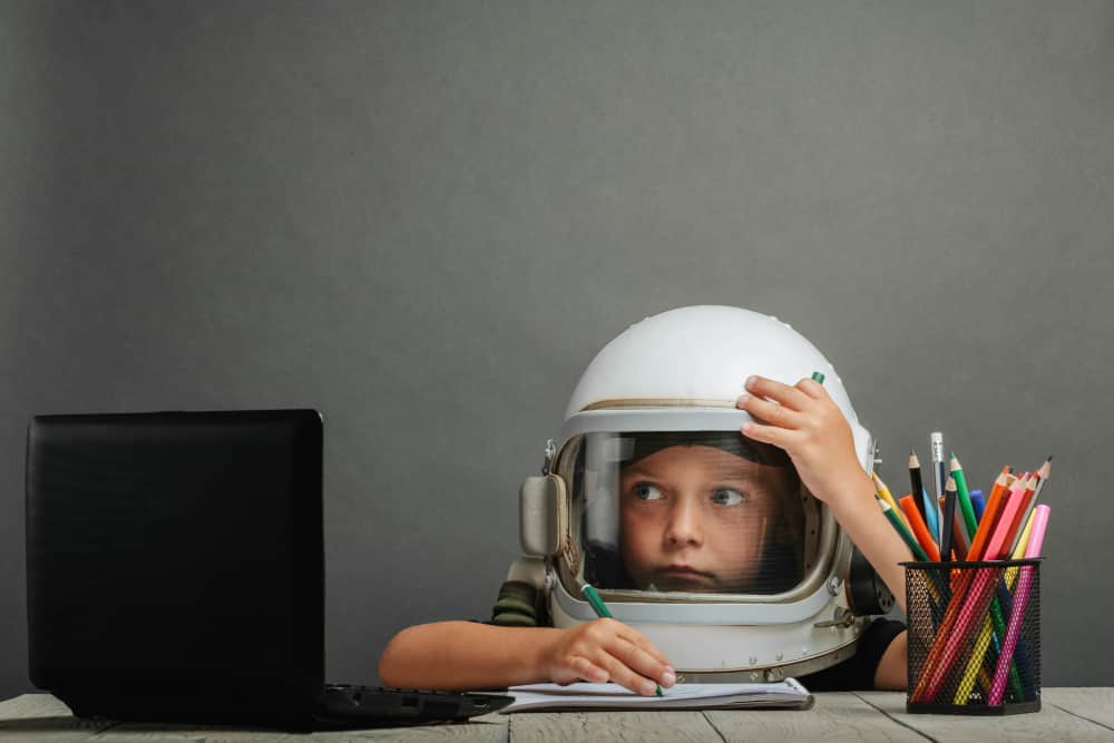 niño con casco de astronauta pensativo